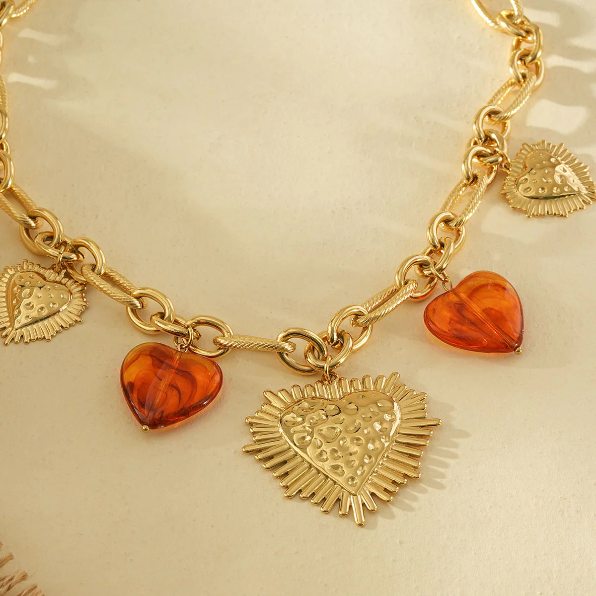 Collier chaîne dorée large cœurs ex-voto martelée et résine marron.