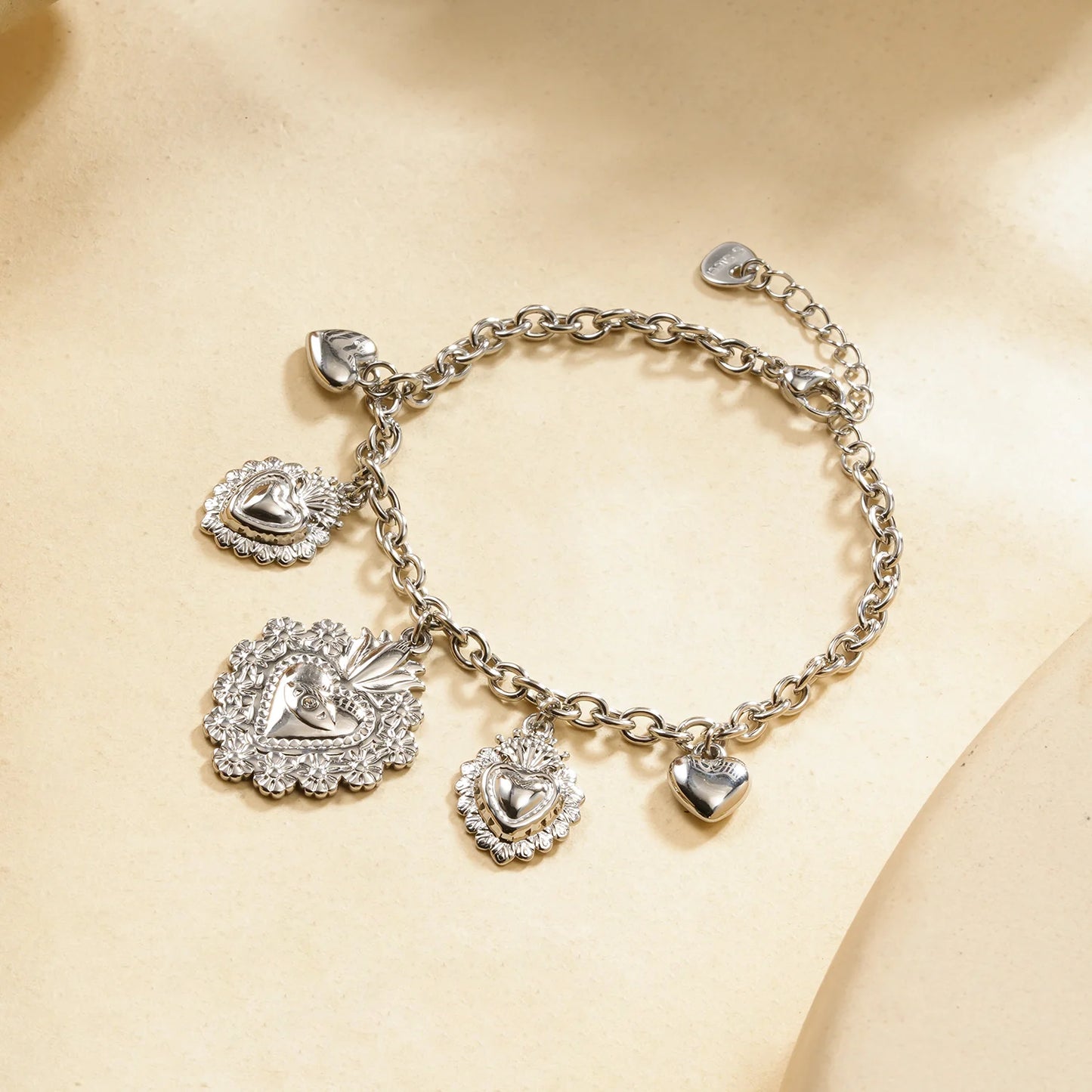 Bracelet chaîne argentée à charms cœurs bombés et ex-voto ciselés